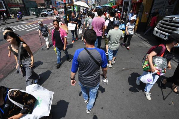 NYPD undercover police officer walking along a crowded sidewalk