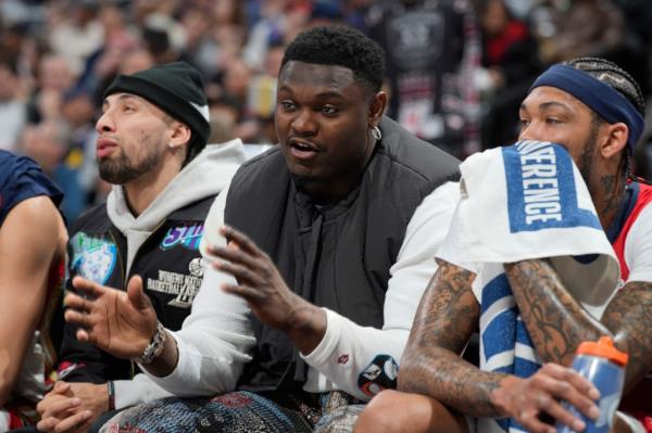 Pelicans forward Zion Williamson, center, sits on the bench