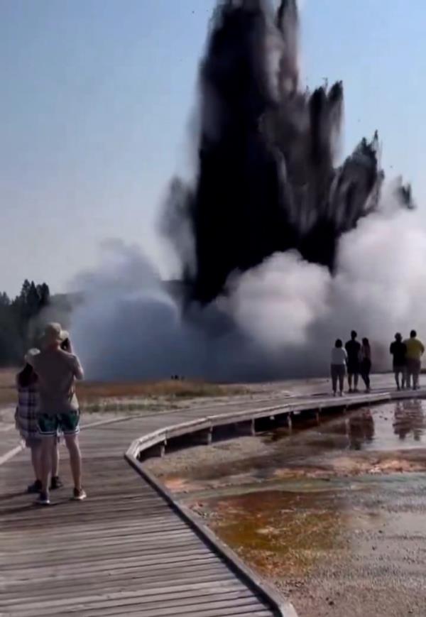 A massive black explosion sends debris and steam hundreds of feet in the air.