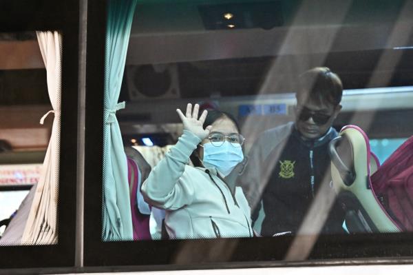 Munkan waves out the window of a bus after being released last week.