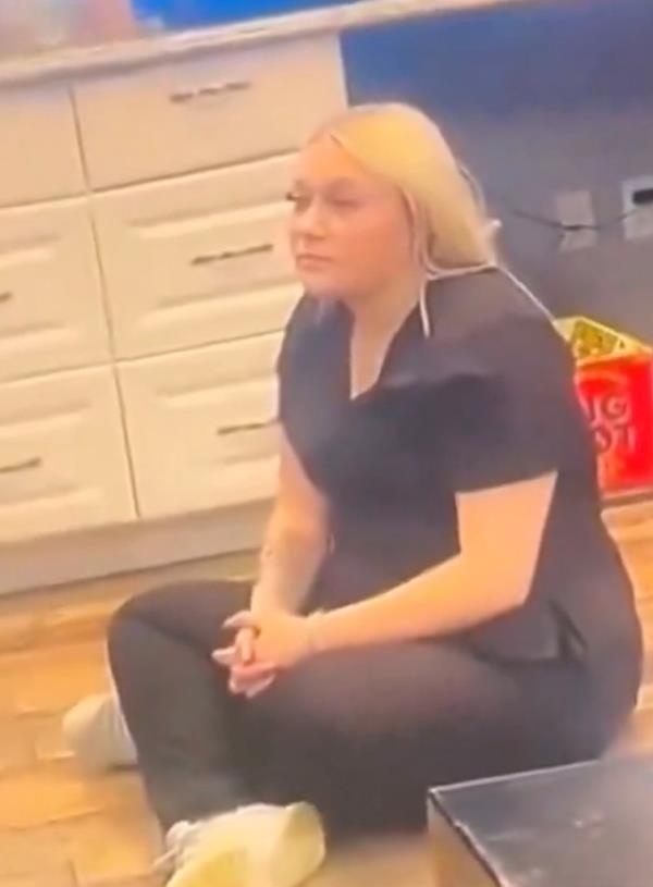A woman sits on the floor and listens.