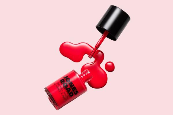 Red nail polish spilling out of a bottle