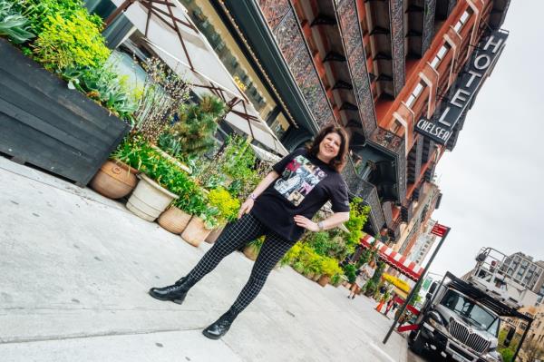 Amanda Rykoff wears a Taylor Swift shirt and stands in front of the Chelsea Hotel.