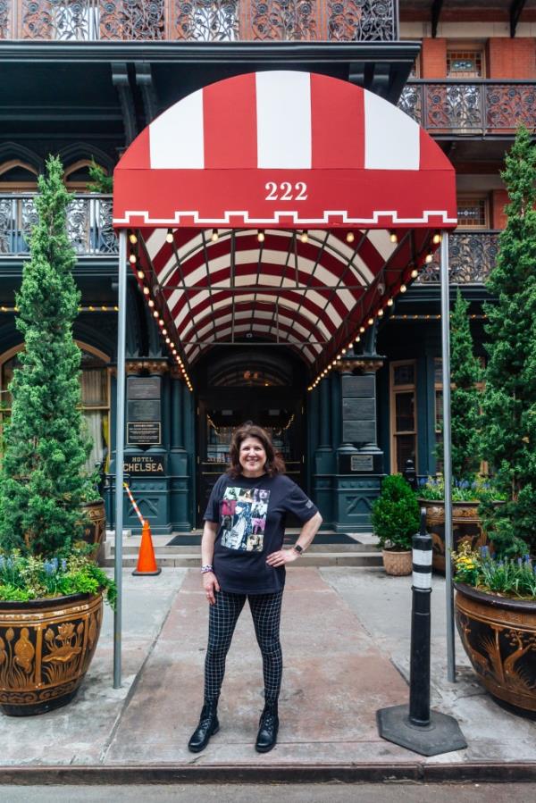 Amanda Rykoff stands beneath the Chelsea Hotel awning wearing a Taylor Swift shirt. 