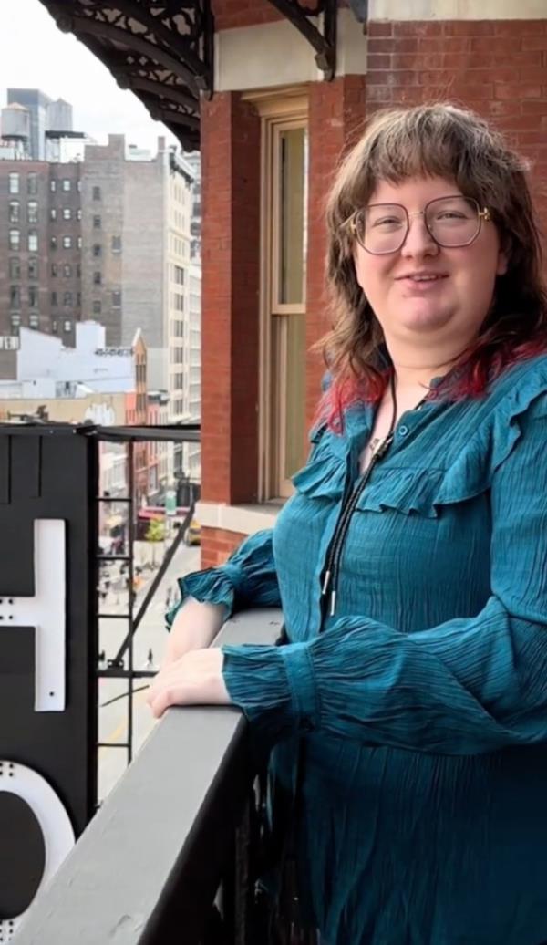A woman stands on a balcony at the Chelsea Hotel.