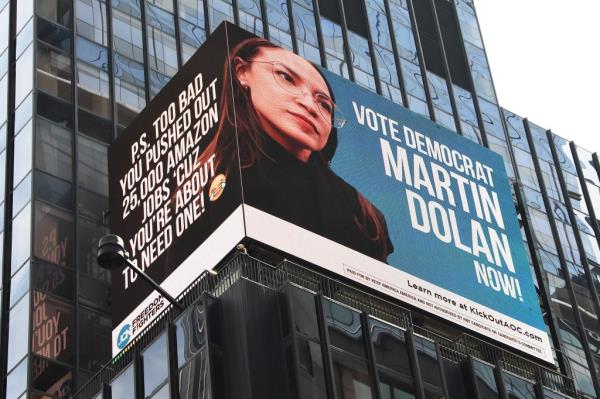 Electro<em></em>nic billboard displaying Martin Dolan's ads against AOC on the side of a building at 1500 Broadway in Times Square