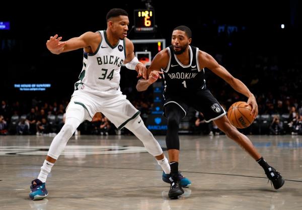 Nets forward Mikal Bridges (1) drives to the basket against Milwaukee Bucks forward Giannis Antetokounmpo (34)
