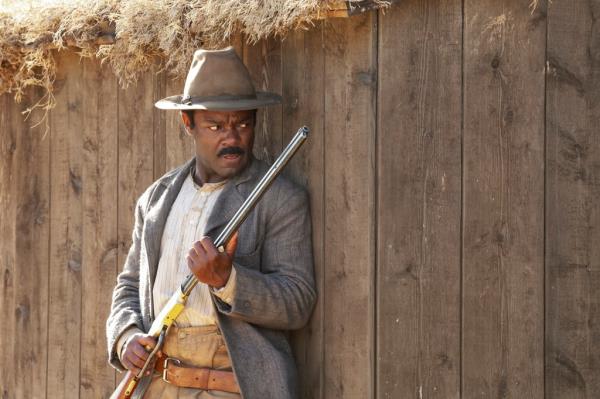 David Oyelowo holding a rifle. 