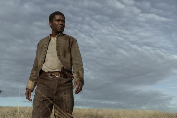 David Oyelowo standing against a field landcaspe. 