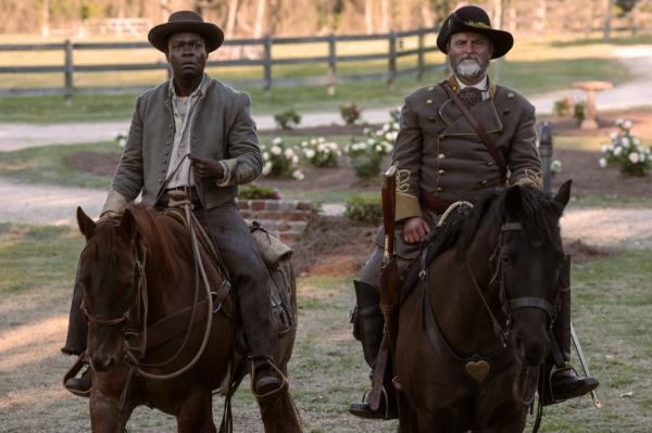 David Oyelowo as Bass Reeves and Shea Whigham as George Reeves, the man who enslaved him, riding next to each other on horses. 