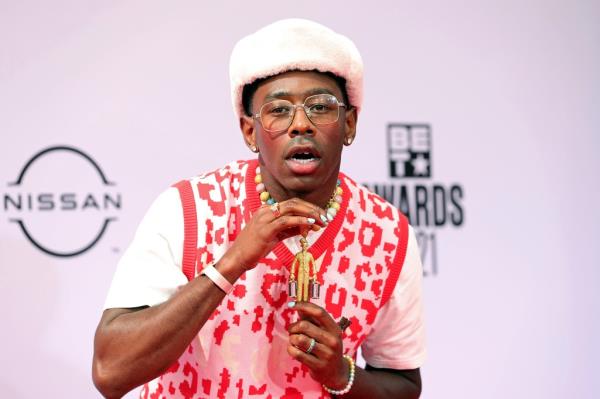 Tyler, The Creator in a white hat and red sweater, wearing the Bellhop Necklace at the BET Awards 2021