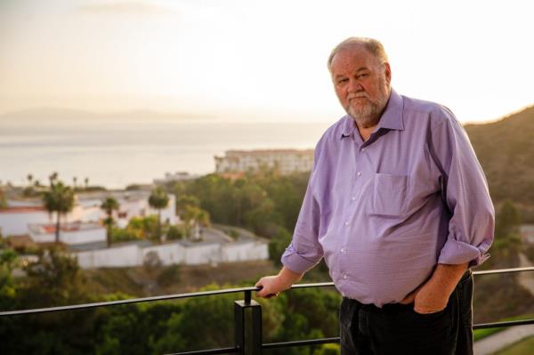Thomas Markle, standing on a balcony with ocean and buildings in the background, during an interview in Rosarito, Mexico