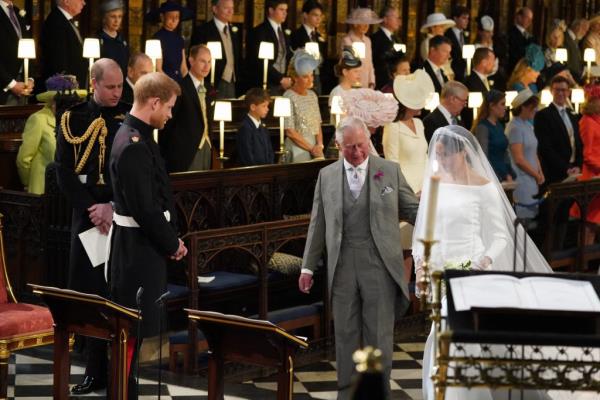 Prince Charles accompanying Meghan Markle in a white dress, down the aisle at her wedding with Prince Harry in 2018