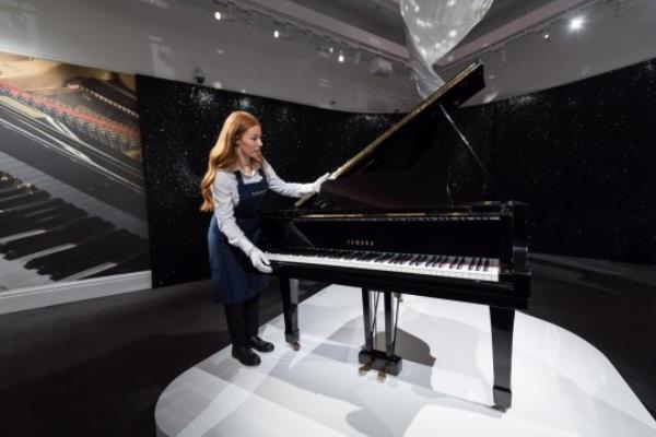 LONDON, UNITED KINGDOM - AUGUST 03: An art handler is seen next to Freddie Mercury's treasured Yamaha Baby Grand Piano (estimate 2,000,000-3,000,000) on which he composed over a decade of hits during a photocall at Sotheby's auction house for the unveiling of Freddie Mercury's entire private collection ahead of an exhibition and six dedicated sales in London, United Kingdom on August 03, 2023. 'Freddie Mercury: A World of His Own' exhibition starring stage costumes, handwritten lyrics, fine and decorative arts, Japanese art, precious objects and a trove of perso<em></em>nal belo<em></em>ngings will be open to the public between August 4th and September 5th, before the items are offered across six dedicated auctions, each one devoted to a different aspect of Mercurys life, both public and private. (Photo by Wiktor Szymanowicz/Anadolu Agency via Getty Images)