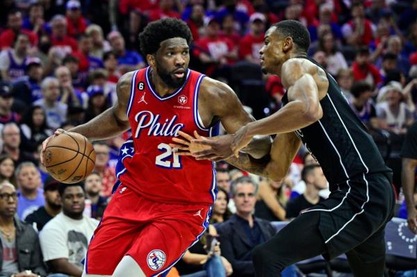 Philadelphia 76ers' Joel Embiid, left, dibbles the ball as Brooklyn Nets' Nic Claxton defends in the second half during Game 1 in the first round of the NBA basketball playoffs, Saturday, April 15, 2023, in Philadelphia.