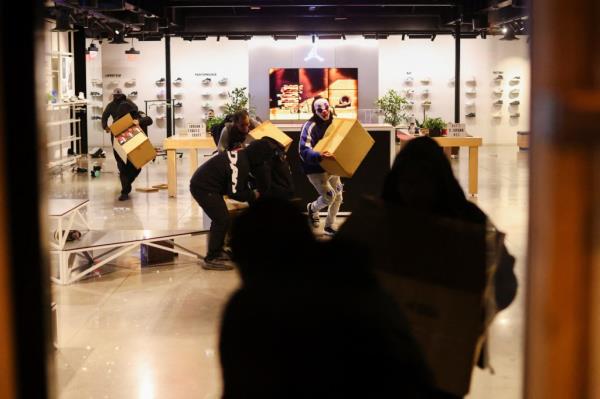 People loot a shoe store during celebrations after the Los Angeles Dodgers' victory over the New York Yankees 