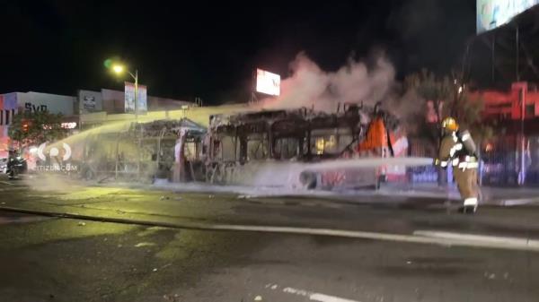 Firefighters were seen extinguishing the charred remains of the bus