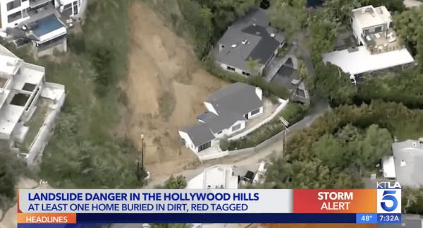 The landslide damage seen from above. Dirt covers a<em></em>bout half of a white house.