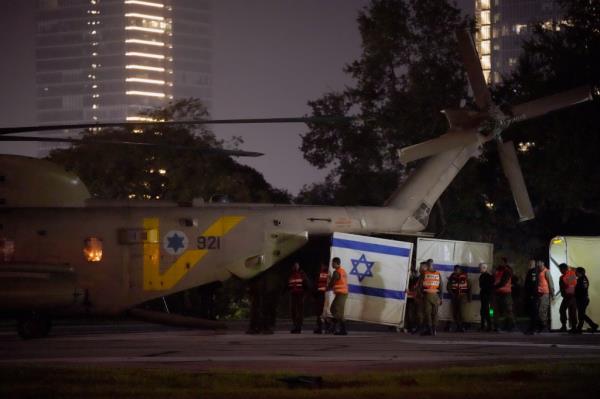 A helicopter is seen arriving with hostages at Schneider medical centre wher<em></em>e they disembarked behind screens as family and friends wait nearby on November 24, 2023 in Petah Tivka, Israel