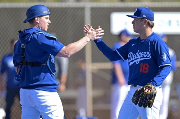 Los Angeles Dodgers starting pitcher Yoshinobu Yamamoto (18) shakes hands with catcher Will Smith (16) during a spring training workout.