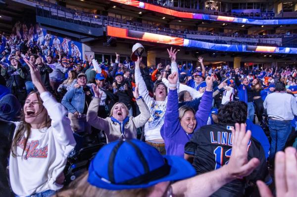Mets fans, attending a watch party at Citi Field, celebrate during their Game 3 victory against the Brewers.