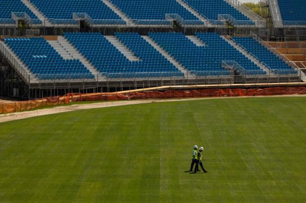Co<em></em>nstruction workers walk on the pitch at the Nassau county Internatio<em></em>nal Cricket Stadium