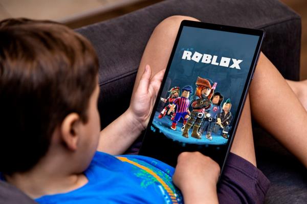 Little boy playing Roblox game on a tablet.