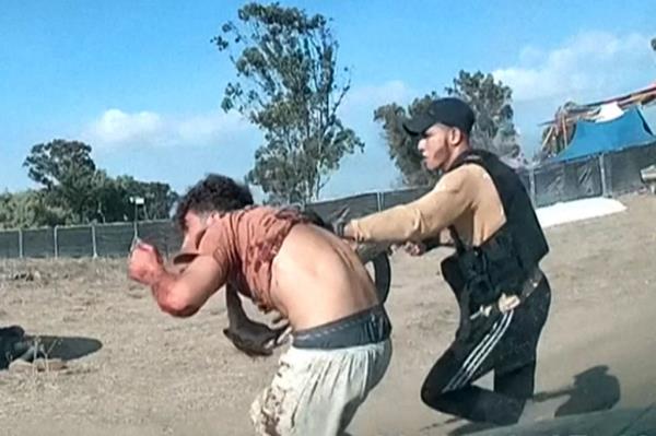  A grab from a UGC video posted on Telegram on October 9, 2023, shows an armed Palestinian militant leading a man during the Supernova music festival.