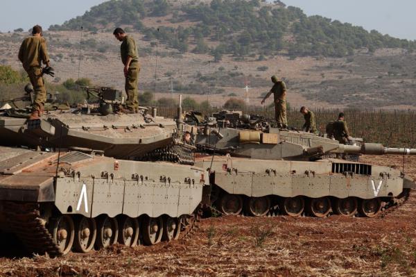 Israeli Merkava tanks in action during maneuvers at an undisclosed location along the border with Lebanon, in Israel.