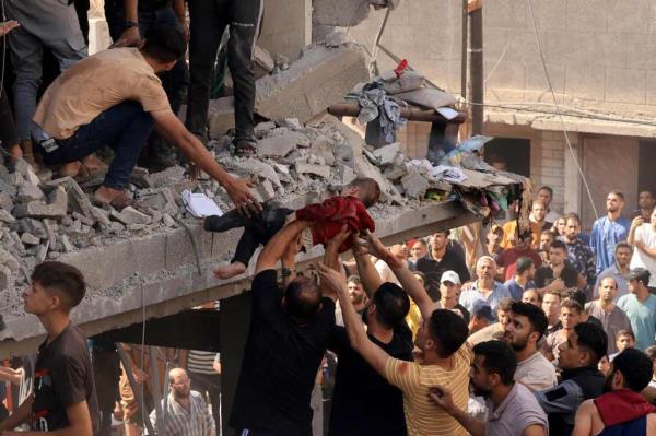 Rescuers pull a child out of the rubble of a building hit in an Israeli air strike in Khan Yunis.
