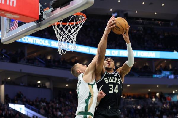 Giannis Antetokounmpo #34 of the Milwaukee Bucks drives to the basket against Kristaps Porzingis #8 of the Boston Celtics during the first half of a game at Fiserv Forum.