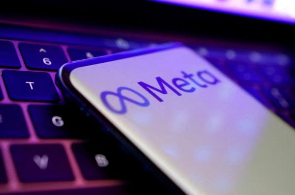 Illustration of me<em></em>ta logo seen on a cellphone placed on a keyboard.