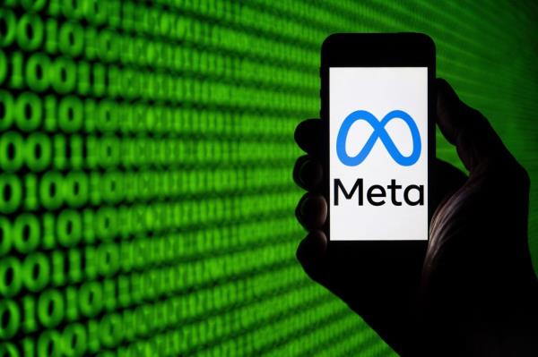 me<em></em>ta logo on a smartphone with code in the background.