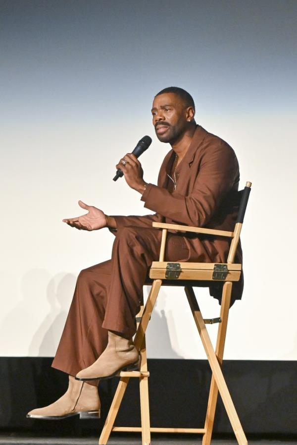 Colman Domingo sitting in a chair holding a mic. 