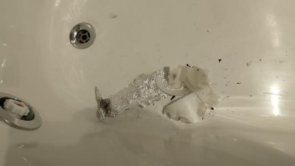 in the bathtub, remains of wax and crumpled and burnt aluminum foil can be seen.
