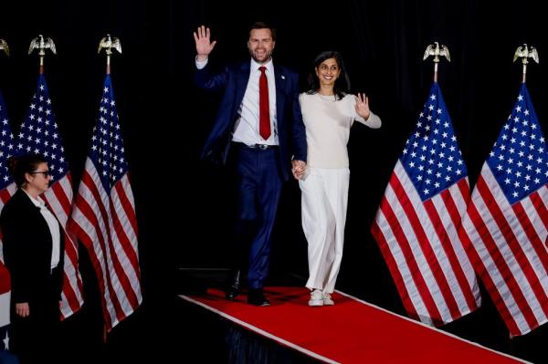 Republican vice presidential nominee Senator JD Vance and his wife Usha at an Election Day eve campaign rally in Atlanta, Georgia, walking on a red carpet with flags.