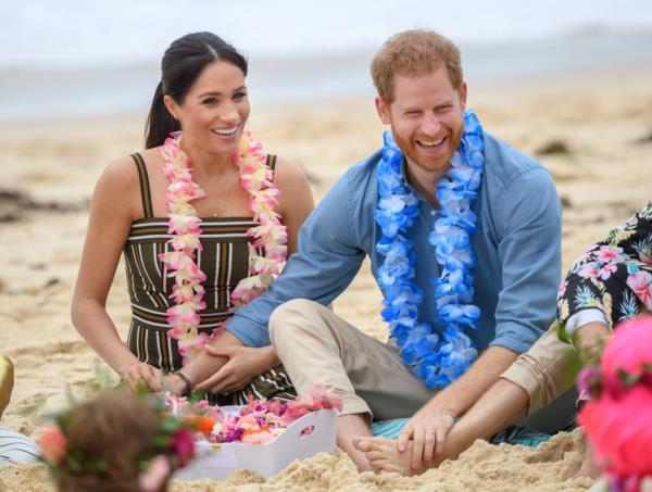 Prince Harry and Meghan, the Duke and Duchess of Sussex, sitting on Bo<em></em>ndi beach with flowers during their official tour in Sydney, Australia in October 2018