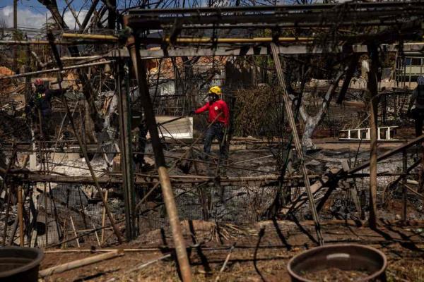 Search and recovery team members check charred buildings and cars in the aftermath of the Maui wildfires in Lahaina, Hawaii, on August 18, 2023.