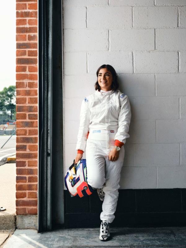 Jamie Chadwick poses in a professio<em></em>nal photo, holding her racing helmet.
