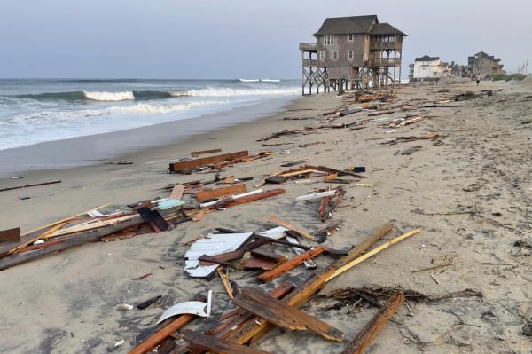 Debris from the home is seen washed up on shore.