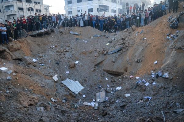 Palestinians gathered at a crater in Rafah after an Israeli strike in Gaza on Dec. 3, 2023.