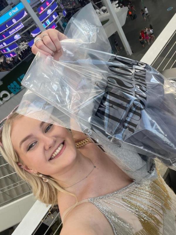 Emily Knight holding up the merch she bought at Taylor Swift's Eras tour