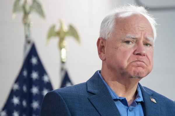 Democratic vice presidential candidate Tim Walz, in a blue shirt, speaking at a campaign rally in Wayne, Michigan alo<em></em>ngside Kamala Harris