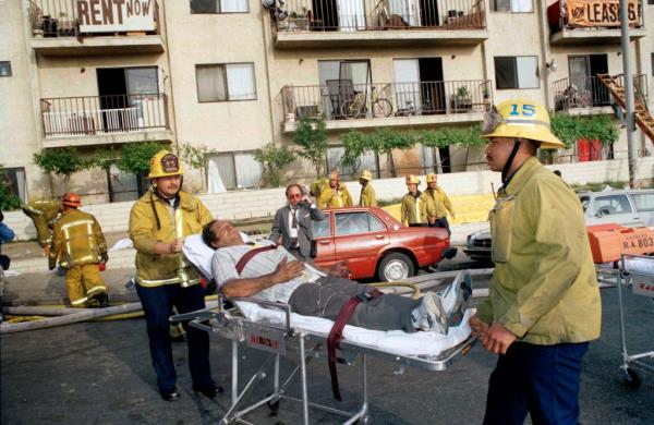 In this May 3, 1993, file photo, a survivor of an apartment complex fire is wheeled to an ambulance by Los Angeles Fire Department perso<em></em>nnel near downtown Los Angeles