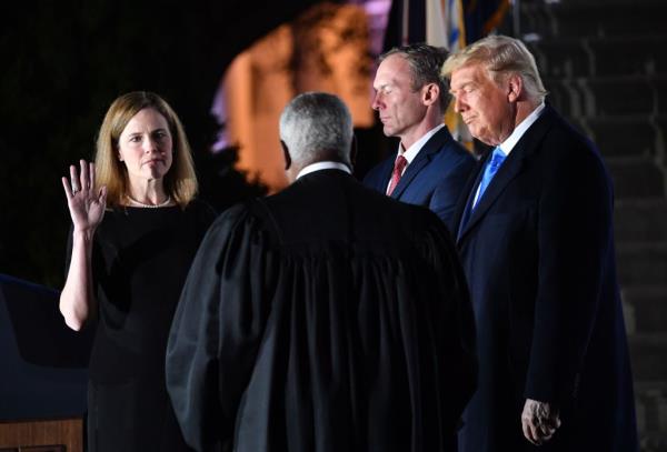US President Do<em></em>nald Trump watching Justice Clarence Thomas swear in Amy Co<em></em>ney Barrett as a US Supreme Court Associate Justice on the South Lawn of the White House