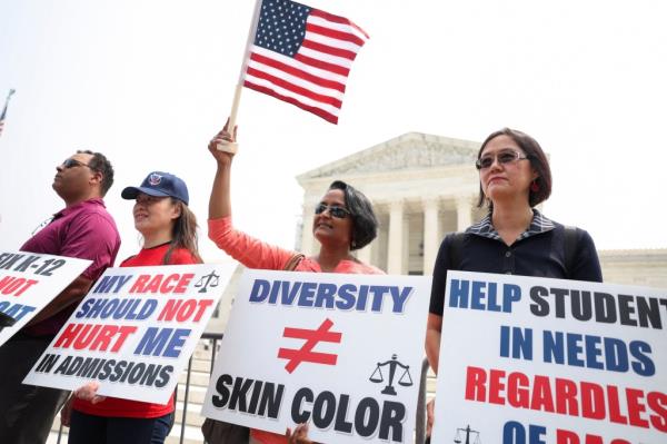 Protesters hold signs as demo<em></em>nstrators for and against the U.S. Supreme Court decision to strike down affirmative action co<em></em>nfront each other on June 29.