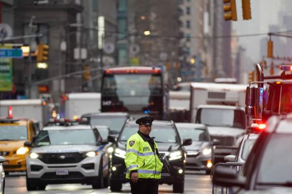 NYPD officer in a yellow jacket directing traffic in the city.