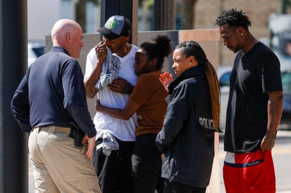 Tampa Police Chief Lee Bercaw speaks with Emmitt Wilson, center, near the scene wher<em></em>e his son 14-year-old Elijah Wilson was killed.