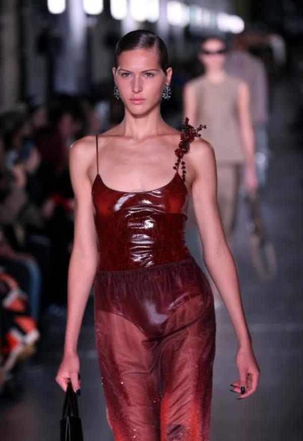 A model walks the runway in a red dress for Tory Burch Fall/Winter 2024 New York Fashion Week at New York Public Library.