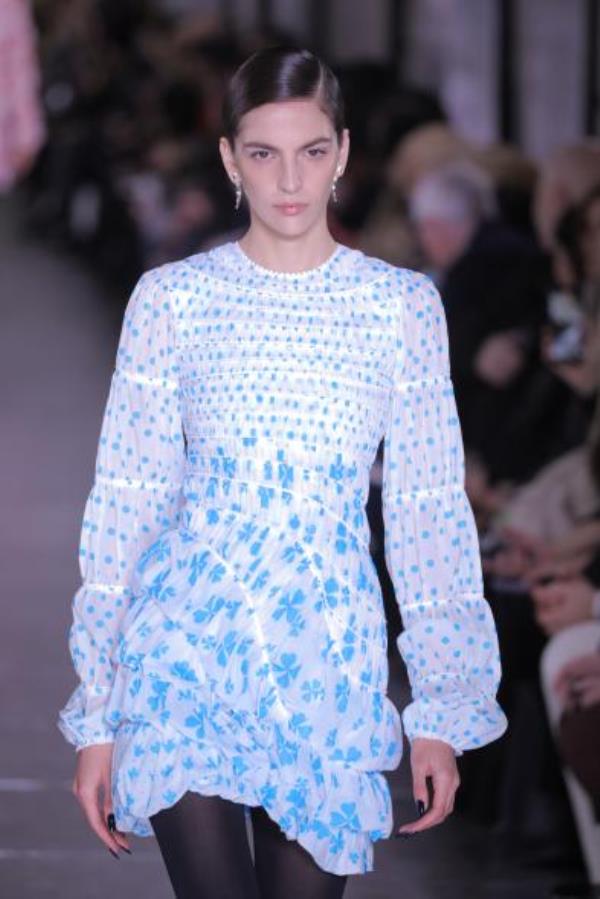 A model walks the runway for the Tory Burch Fall/Winter 2024 Fashion Week show wearing a blue and white dress at New York Public Library.